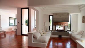 Uma sala de estar moderna com lareira, janelas amplas e um espaço de estar aconchegante.