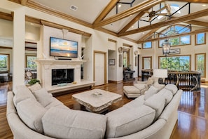Una sala de estar amplia con chimenea, asientos cómodos y ventanas grandes.