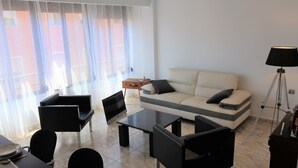 A modern living room with a sofa, two armchairs, a coffee table, and a lamp. - Your central and comfortable 100 sqm flat in Valencia City. 10 Gigabit internet (Valencia)