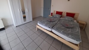 Quarto com cama, guarda-roupa e porta.