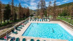 A swimming pool with lounge chairs and umbrellas, surrounded by trees and a clear sky. - Résidence Lalbane - Piscine - Vars Les Claux (Vars)