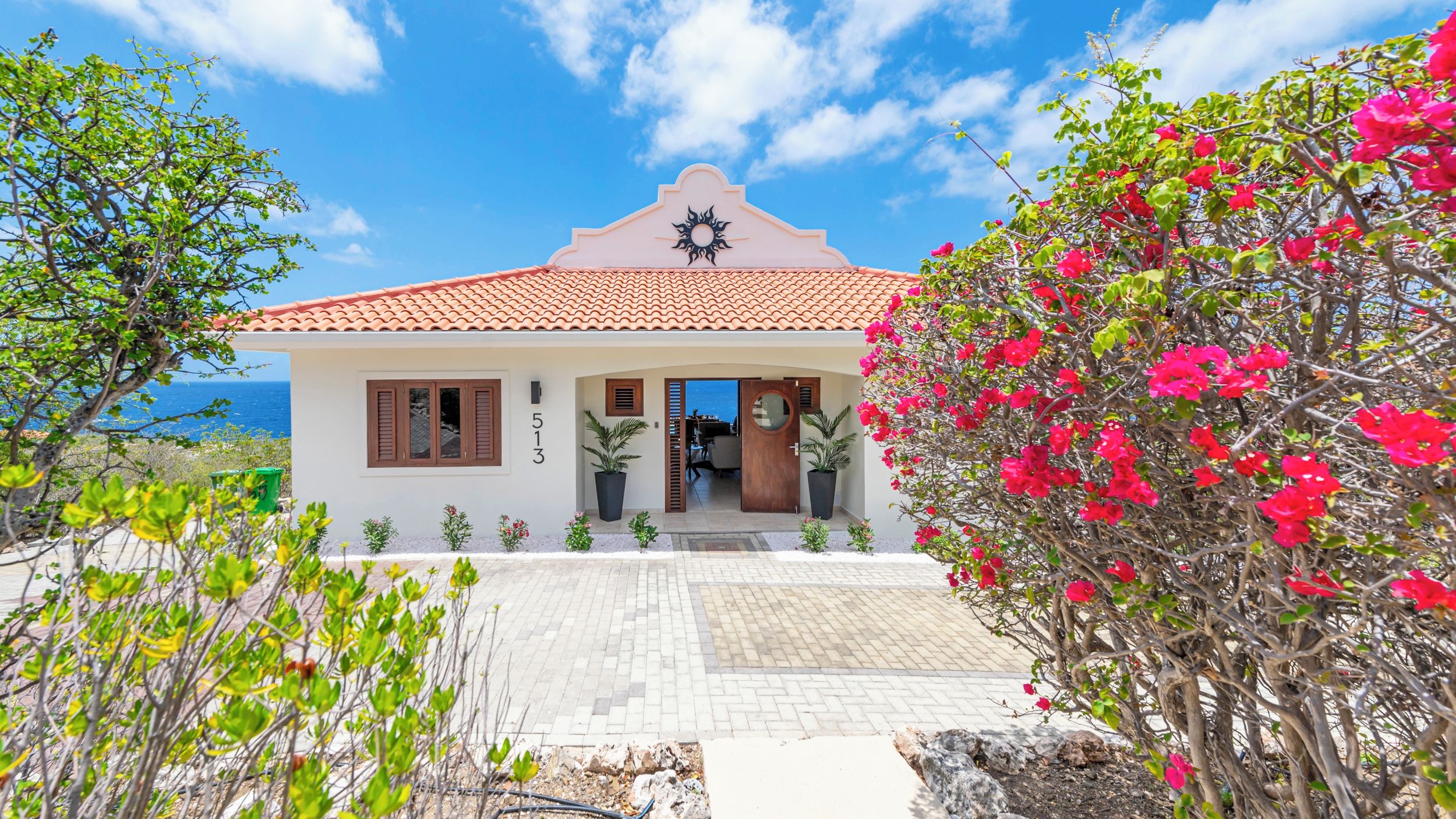 A coastal house with a tiled roof, a balcony, and a view of the sea.
