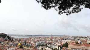 A cityscape with a view of the sea and a bridge in the distance. - Lisbon Grand View (Lisboa)
