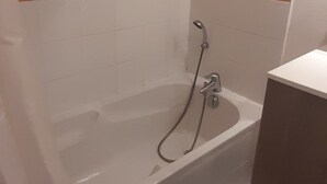 Un baño con bañera, ducha y lavamanos.