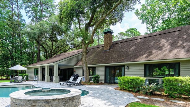 A house with a covered patio, a swimming pool, and a brick pathway. - Spacious, Pet-Friendly Home  Sea Pines Golf Views (Hilton Head Island)