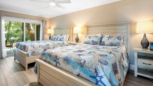 A bedroom with two beds, a ceiling fan, and a view of the outdoors. - Spacious, Pet-Friendly Home  Sea Pines Golf Views (Hilton Head Island)