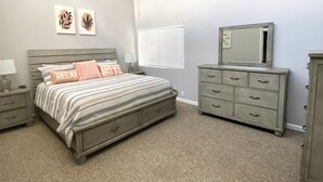 A bedroom with a bed, nightstands, a dresser, a ceiling fan, and artwork on the walls. - CAROL'S GETAWAY near Sandy Beach (Heber Springs)