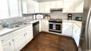 A kitchen with white cabinets, stainless steel appliances, a dishwasher, a microwave, an oven, and a toaster. - CAROL'S GETAWAY near Sandy Beach (Heber Springs)