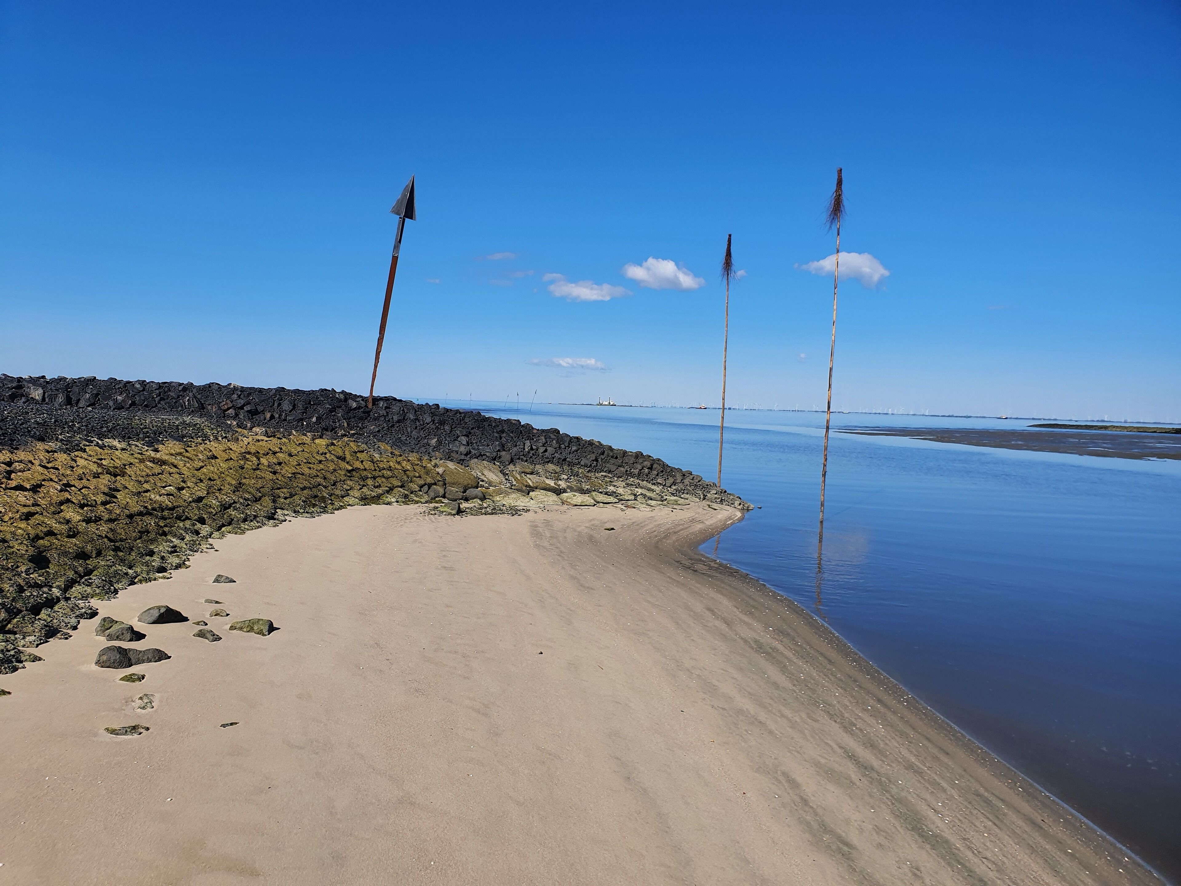 A beach with a rocky shoreline and calm water.