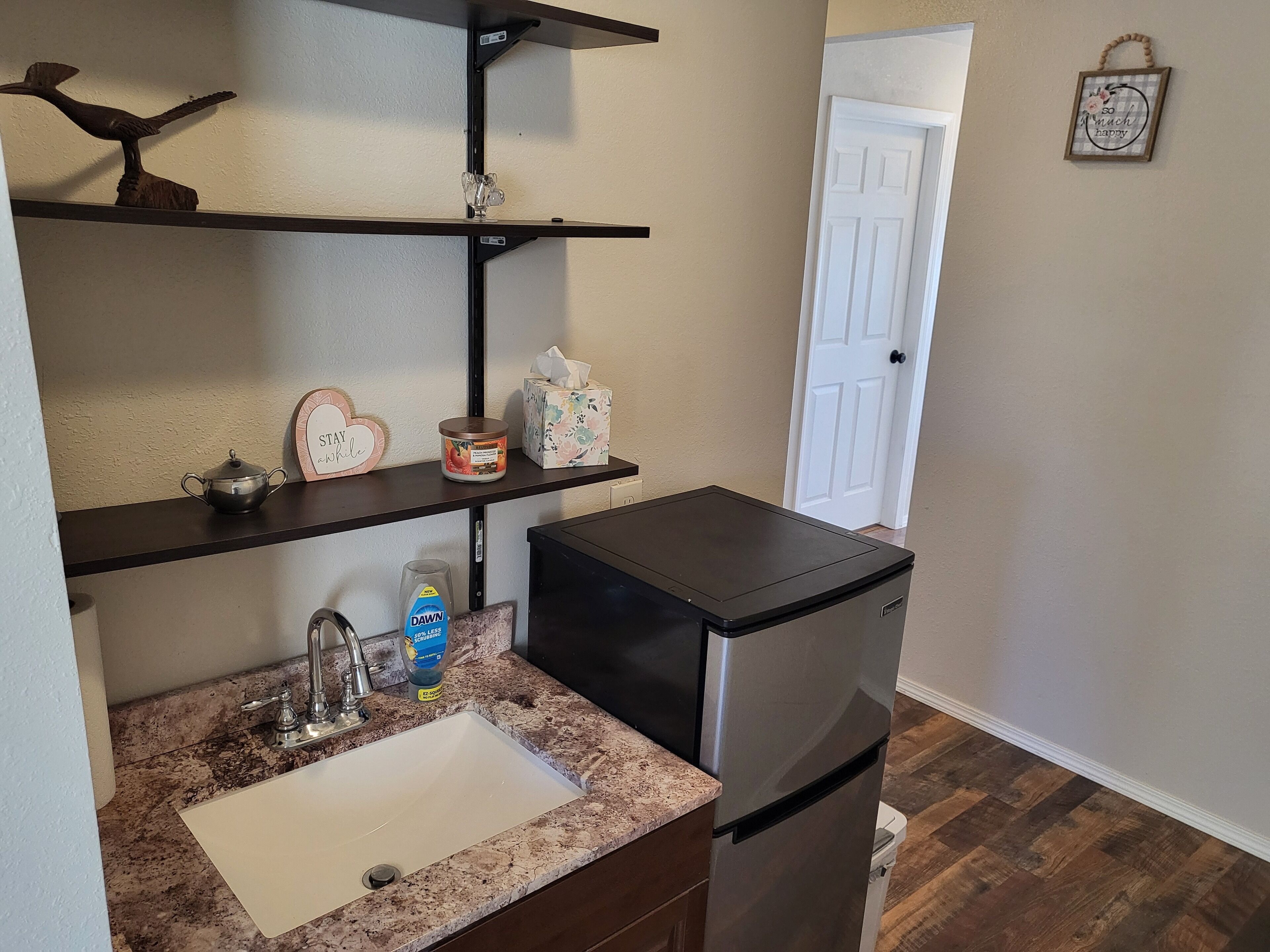 Una cocina compacta con un lavamanos, un refrigerador y una encimera.