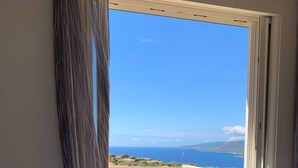 A bedroom with a large window offering a view of the sea and distant hills. - Villa Contemporaine D'exception à 5 min de Propriano (viggianello)