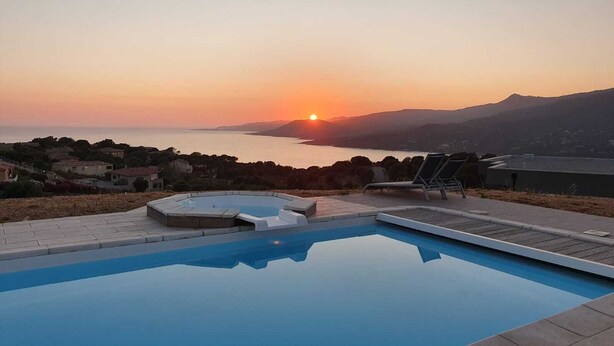 A swimming pool with a view of the sunset over the sea and hills. - Villa Contemporaine D'exception à 5 min de Propriano (viggianello)