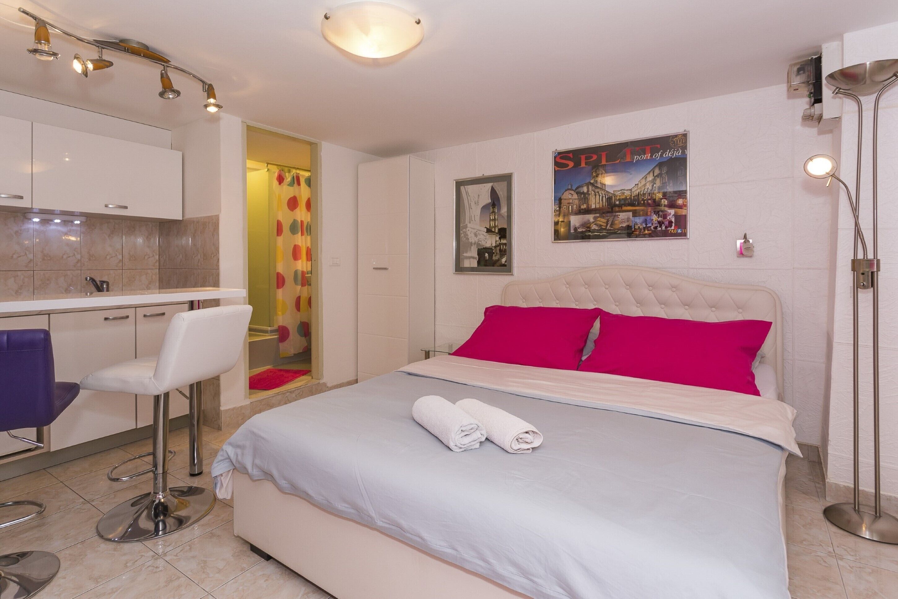 Una habitación de hotel con una cama, un escritorio y una silla.