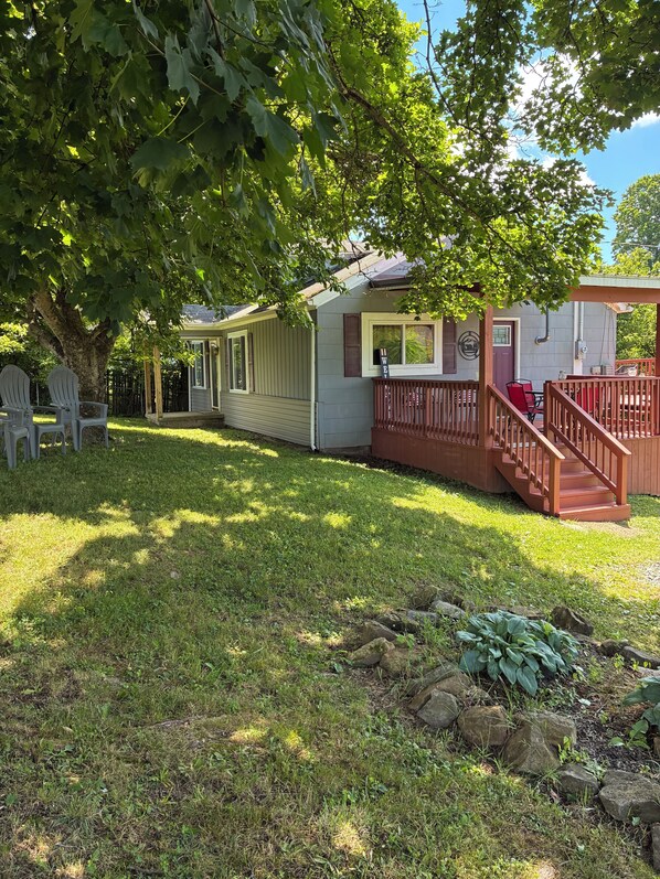 A two-story house with a porch, a small deck, and a fenced yard.