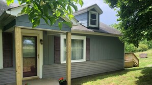 A single-story house with a porch, a small deck, and a front door.