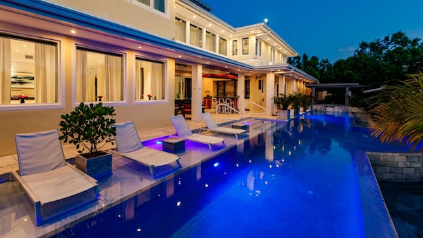 Una casa moderna con piscina, area relax esterna e interni luminosi.
