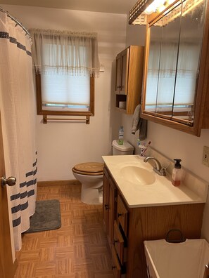 Tina con regadera, toallas, jabón, papel de baño 