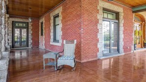 Un patio techado con un edificio de ladrillo, un muro de piedra y un techo de madera.
