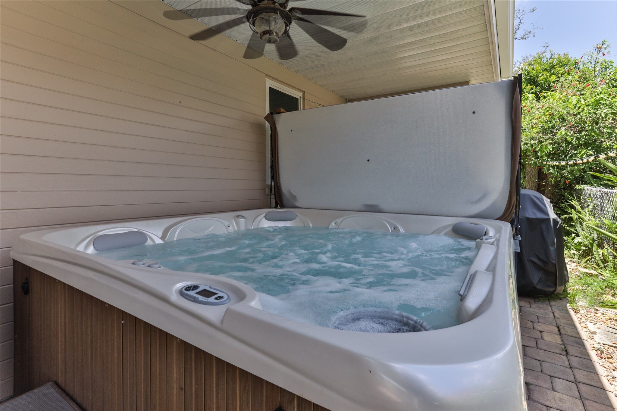 Een hottub met een houten buitenkant en een plafondventilator erboven.