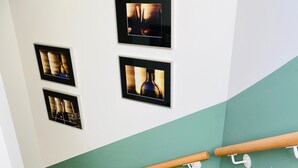 A staircase with wooden steps and a handrail, flanked by teal walls and white trim.