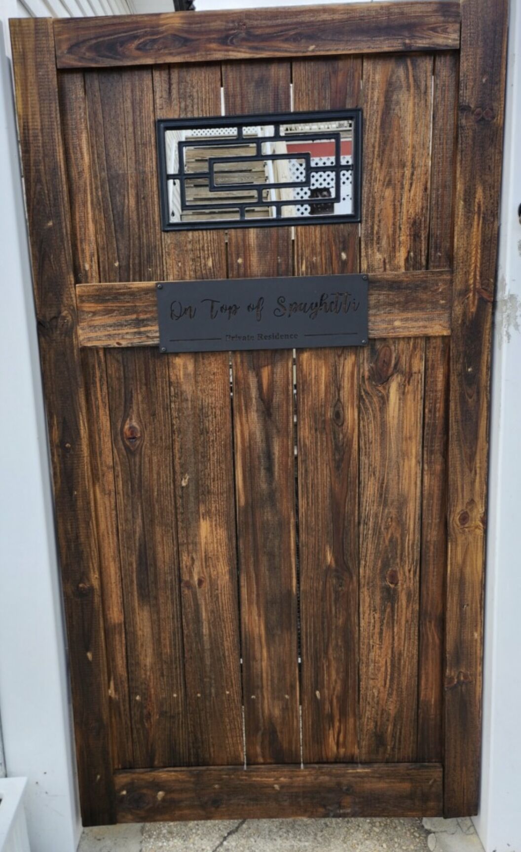 A wooden door with a sign that reads "On Top of Spaghetti - Private Residence."