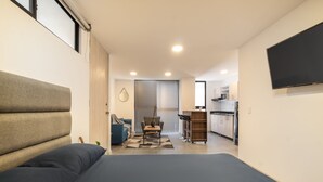 Ein kleines Schlafzimmer mit Bett, einer Sitzecke und einer Küchenzeile.
