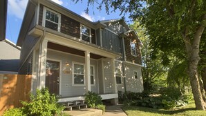 A two-story house with a front porch, a mailbox, and a street sign. - The Nations Home Close to Downtown (Nashville)