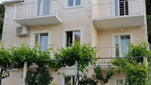 Un immeuble de deux étages doté de balcons et de climatiseurs.