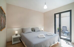 Een moderne slaapkamer met een bed, nachtkastjes en uitzicht.