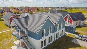 A residential area with houses featuring gabled roofs and a central blue house with a visible staircase. - Beach front apartment in Büsum with sauna (Büsum)