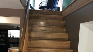 Un escalier en bois avec une paroi vitrée sur le côté gauche.