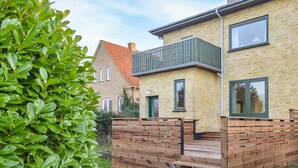 Ett tvåvåningshus med en träveranda och en balkong.