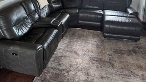 A living room with a sectional sofa, a fireplace, and a window with curtains. - Beautiful! (Black Hawk)