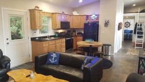 Un espacio habitable compacto con kitchenette, comedor y zona de estar.