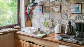 A kitchen with a wooden countertop, a sink, a coffee maker, and a stove. There are hanging kitchen towels and a window with a view of greenery. - 2 bedroom gorgeous apartment in Bandow (Bandow)