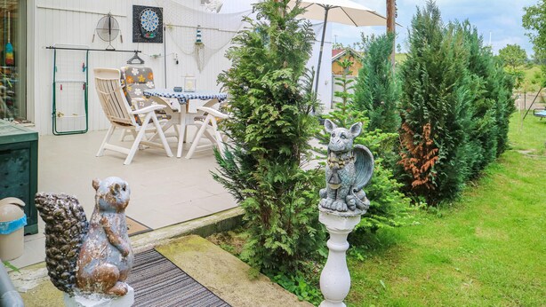A patio area with outdoor furniture, a dartboard, and a small garden with a statue. - 2 bedroom gorgeous apartment in Bandow (Bandow)