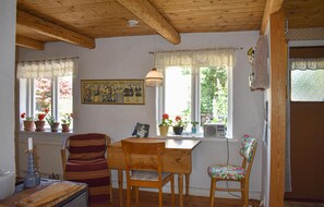 Relax in this charming room with a wooden table, chair, and comfortable bench, perfect for unwinding with a good book or a warm cup of coffee.