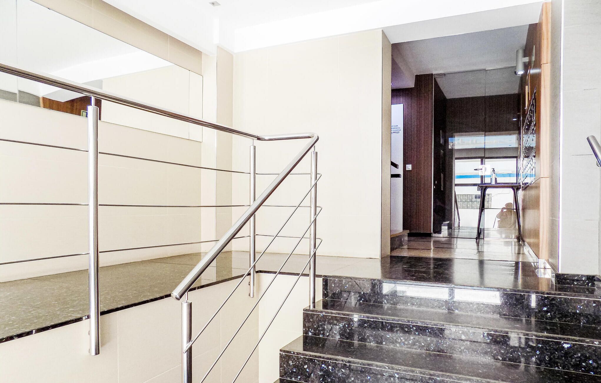 Ein modernes Interieur mit einer Metalltreppe und einem gläsernen Aufzugsschacht.