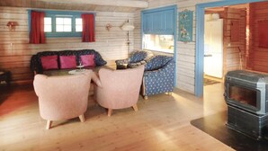 A cozy cabin interior with a wooden floor, a sofa set, a dining table, and a wood-burning stove. - Lovely home in Vikersund with sauna (Vikersund)