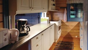 A compact kitchen with white cabinets, a coffee maker, a toaster, and a window with a view of greenery. - Lovely home in Vikersund with sauna (Vikersund)