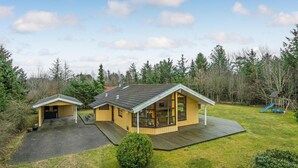 A two-story wooden cabin with a large deck and a separate garage. - Awesome home in Hals with kitchen (Hals)