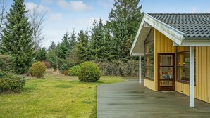 A wooden deck leading to a yellow building with large windows and a tiled roof. - Awesome home in Hals with kitchen (Hals)
