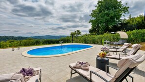A swimming pool with lounge chairs and a view of the mountains. - Luxurious home in Rukljevina with sauna (Rukljevina)