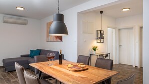 Ein moderner Essbereich mit Holztisch, Stühlen und einer Pendelleuchte.