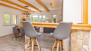 A modern kitchen with a stone countertop, wooden beams, and a view of the outdoors. - 3 bedroom cozy home in Skradin (Skradin)