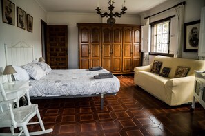 Ein Schlafzimmer mit einem Bett, einem Schaukelstuhl, einer Couch und einem Kleiderschrank.