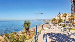 A coastal promenade with a clear view of the sea, a pedestrian walkway, and beachfront buildings. - Beautiful apartment with pool (Torrox-Costa)