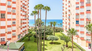 A high-rise hotel with balconies overlooking a well-maintained garden and a view of the sea. - Beautiful apartment with pool (Torrox-Costa)