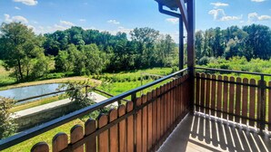 Ein Balkon mit Blick auf einen Fluss und einen Wald.