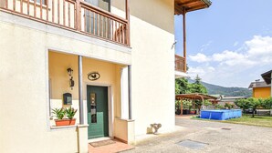 A two-story building with a green door, a balcony with wooden railings, and a sign that reads "BIENVENUE".